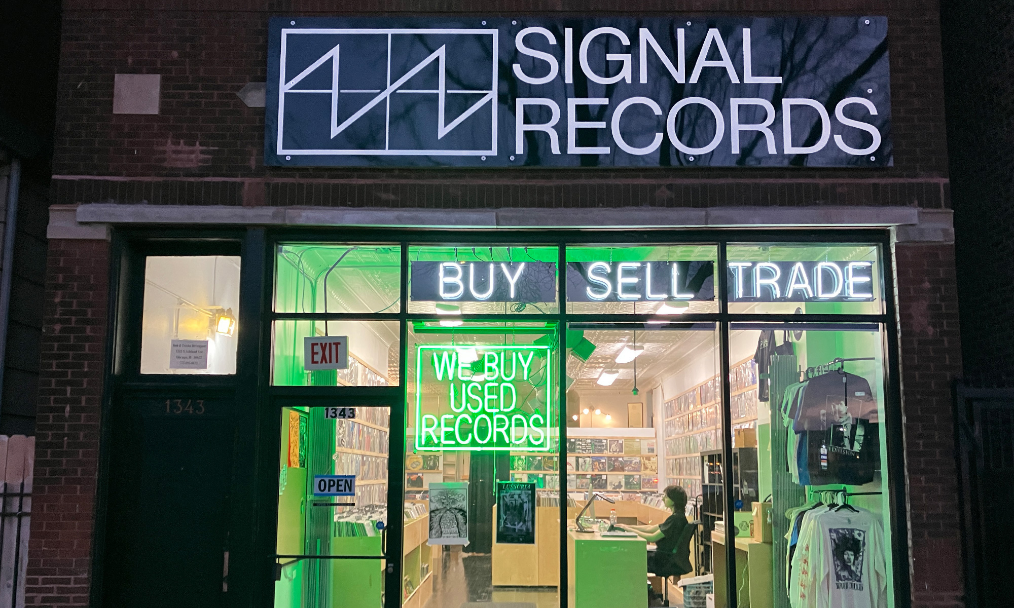 Signal Records storefront, lit for evening browsing.