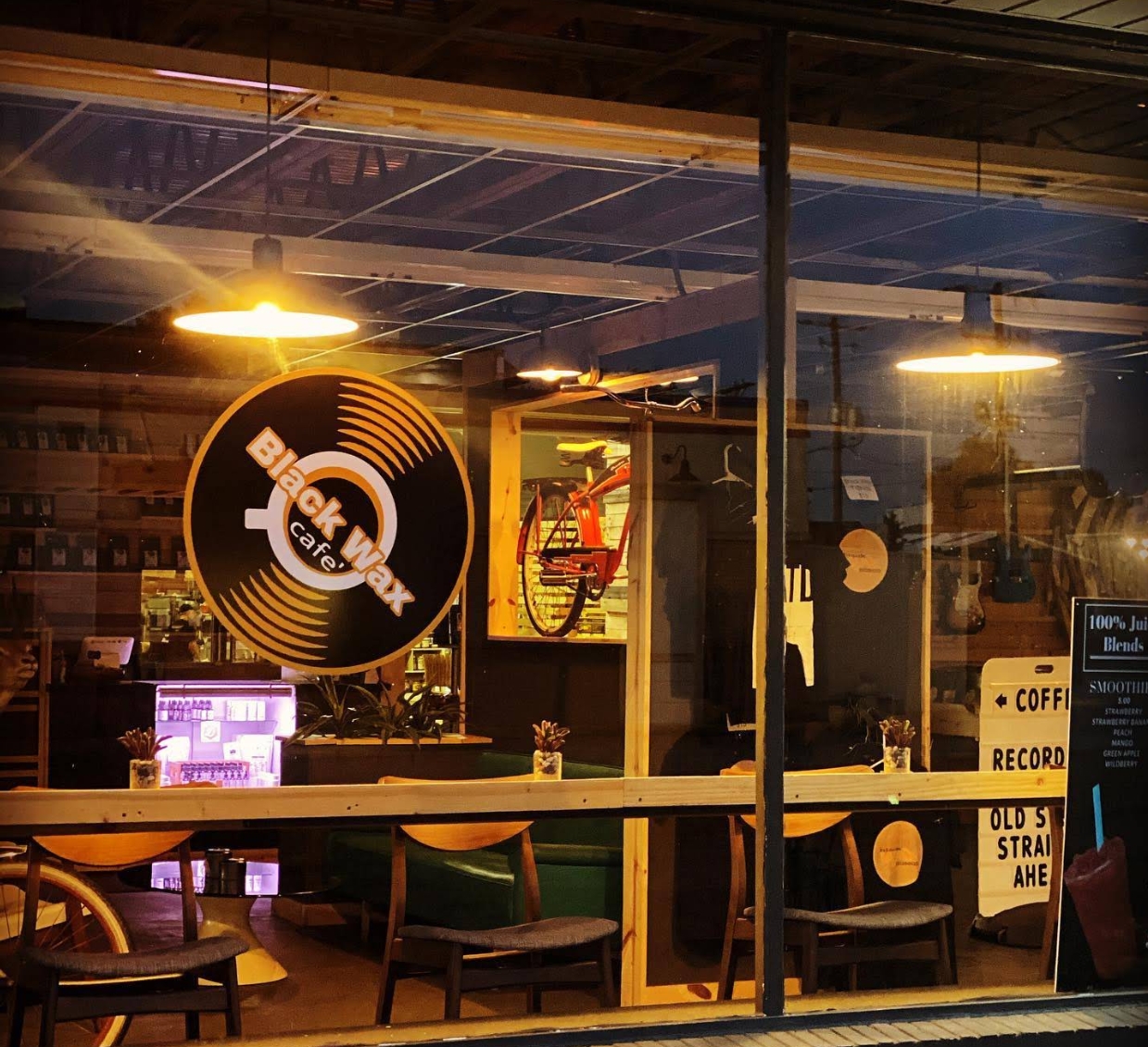 Black Wax Cafe window with seating and record-shop sign